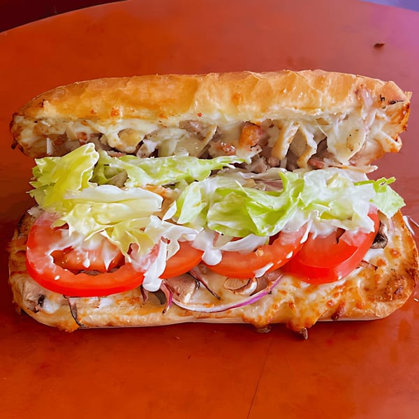 A large, toasted sub sandwich filled with meat, cheese, lettuce, tomatoes, and mayonnaise.